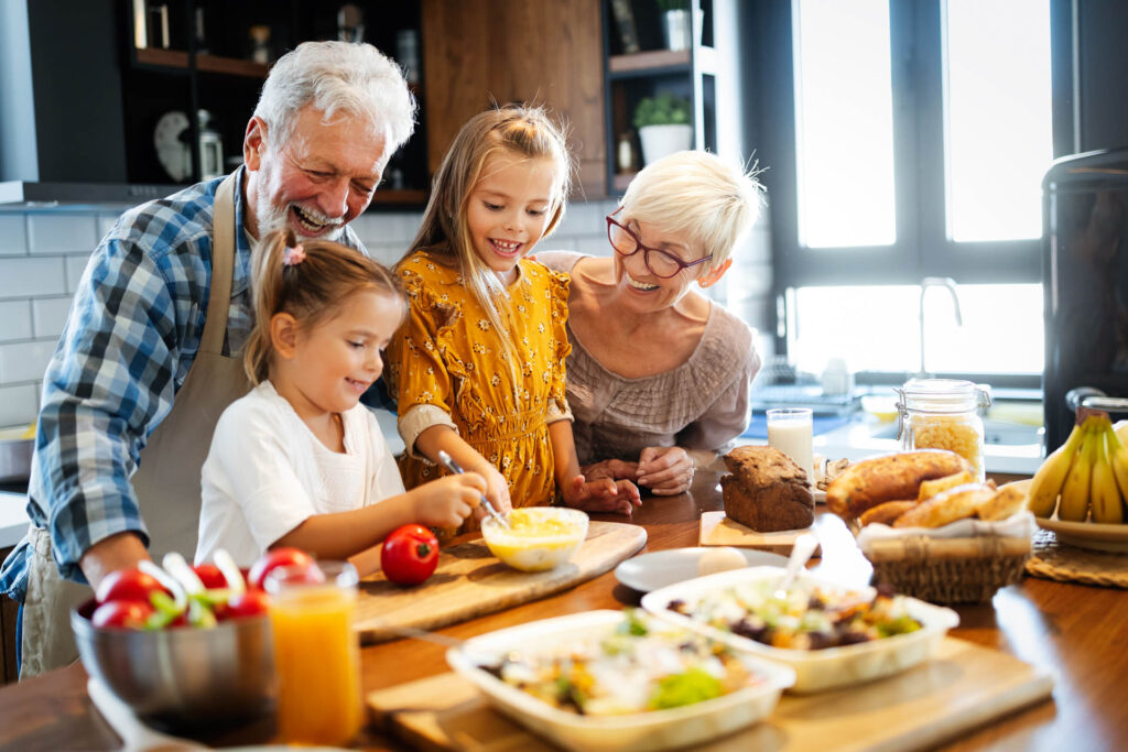 Happy senior couple having breakfast with their grandchildren at home